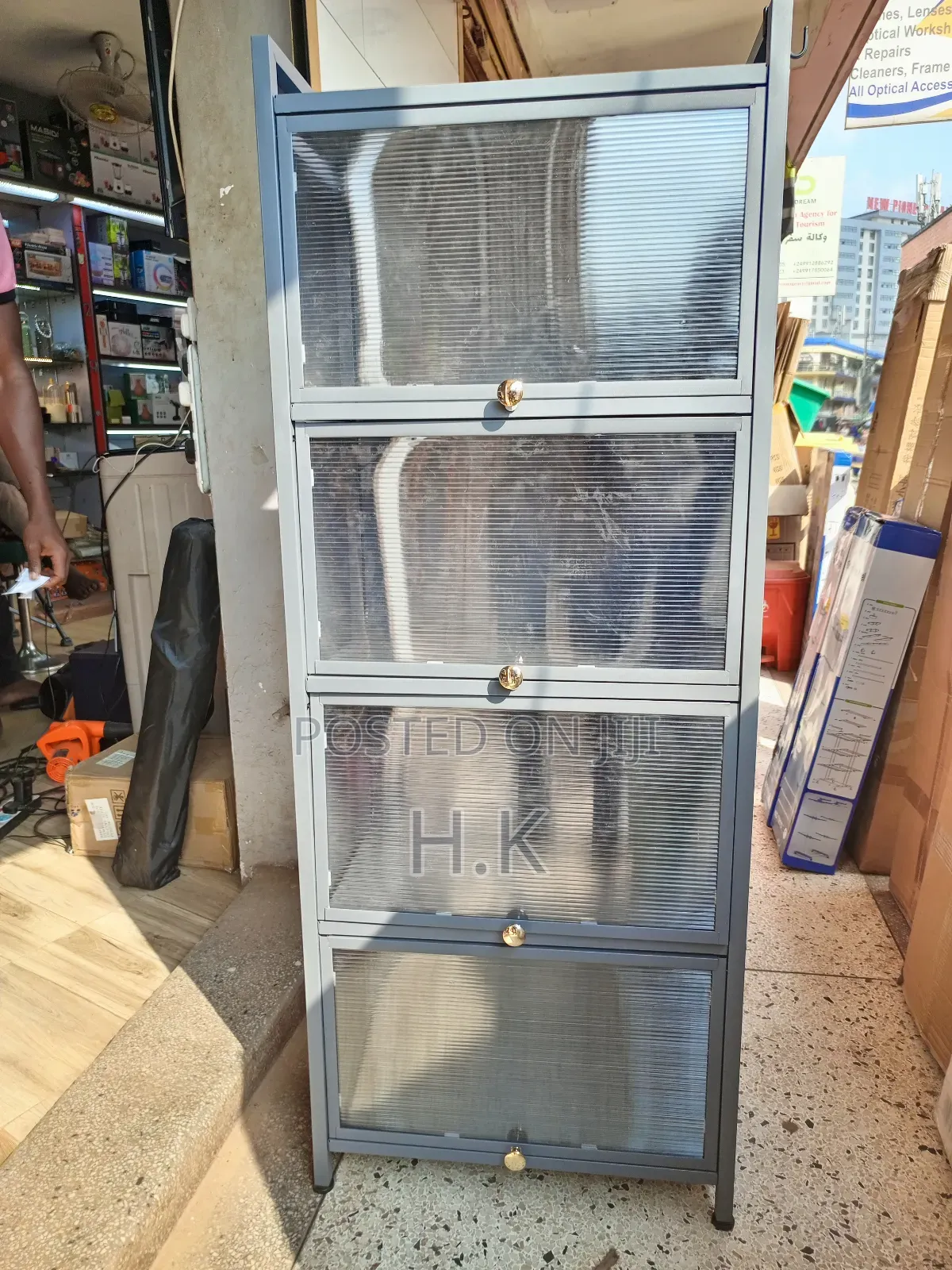Grey Metal Storage Cabinet With Four Glass-Paned Doors.
