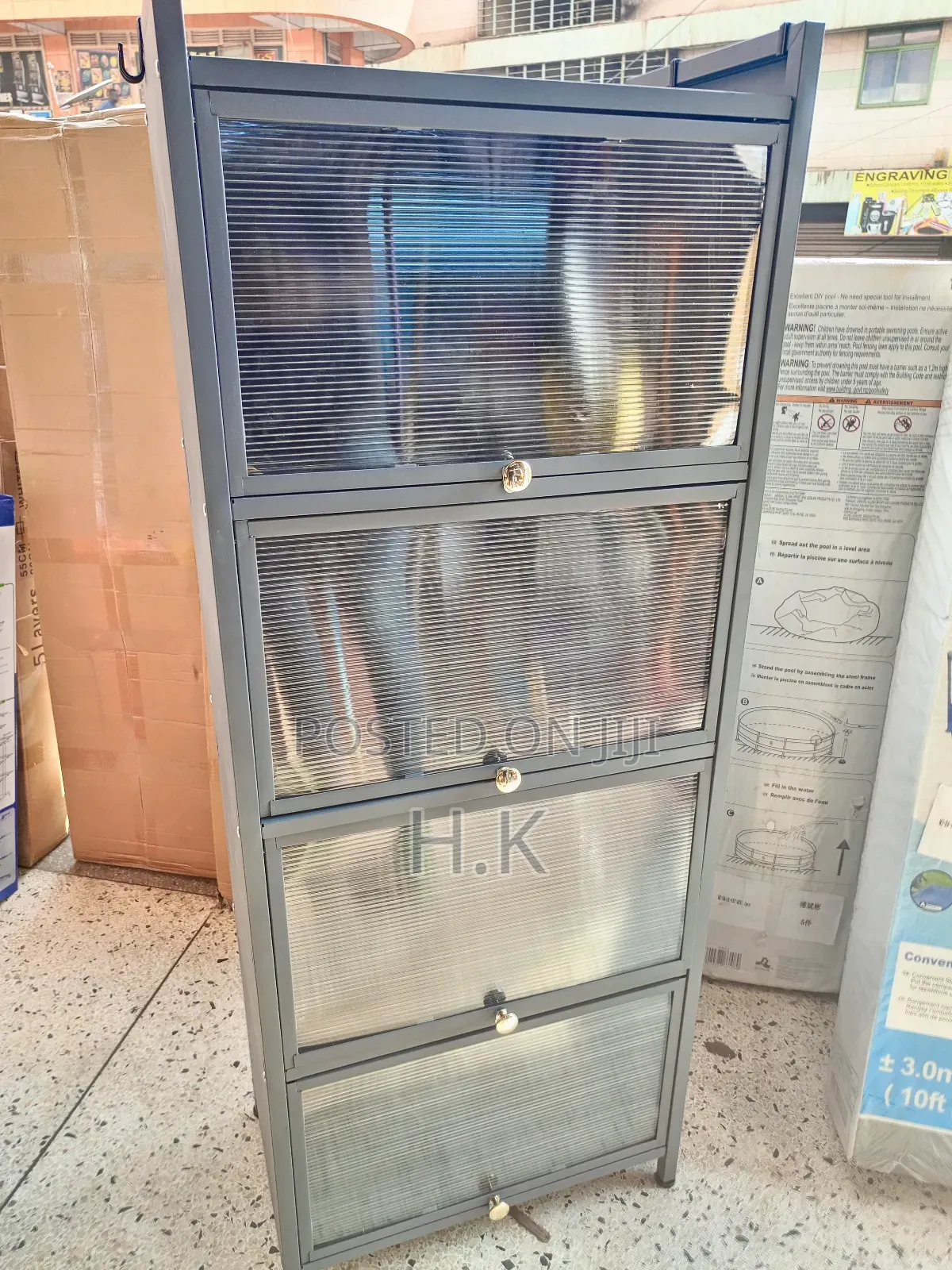 Grey Metal Storage Cabinet With Four Glass-Paned Doors.