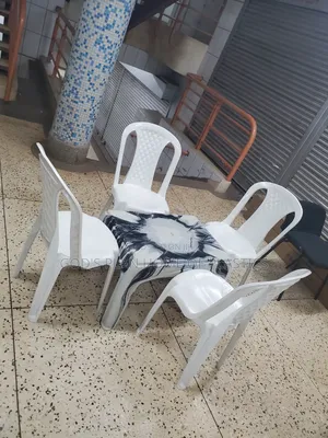 Photo - White Armless Plastic Chairs and Multicolored Plastic Table