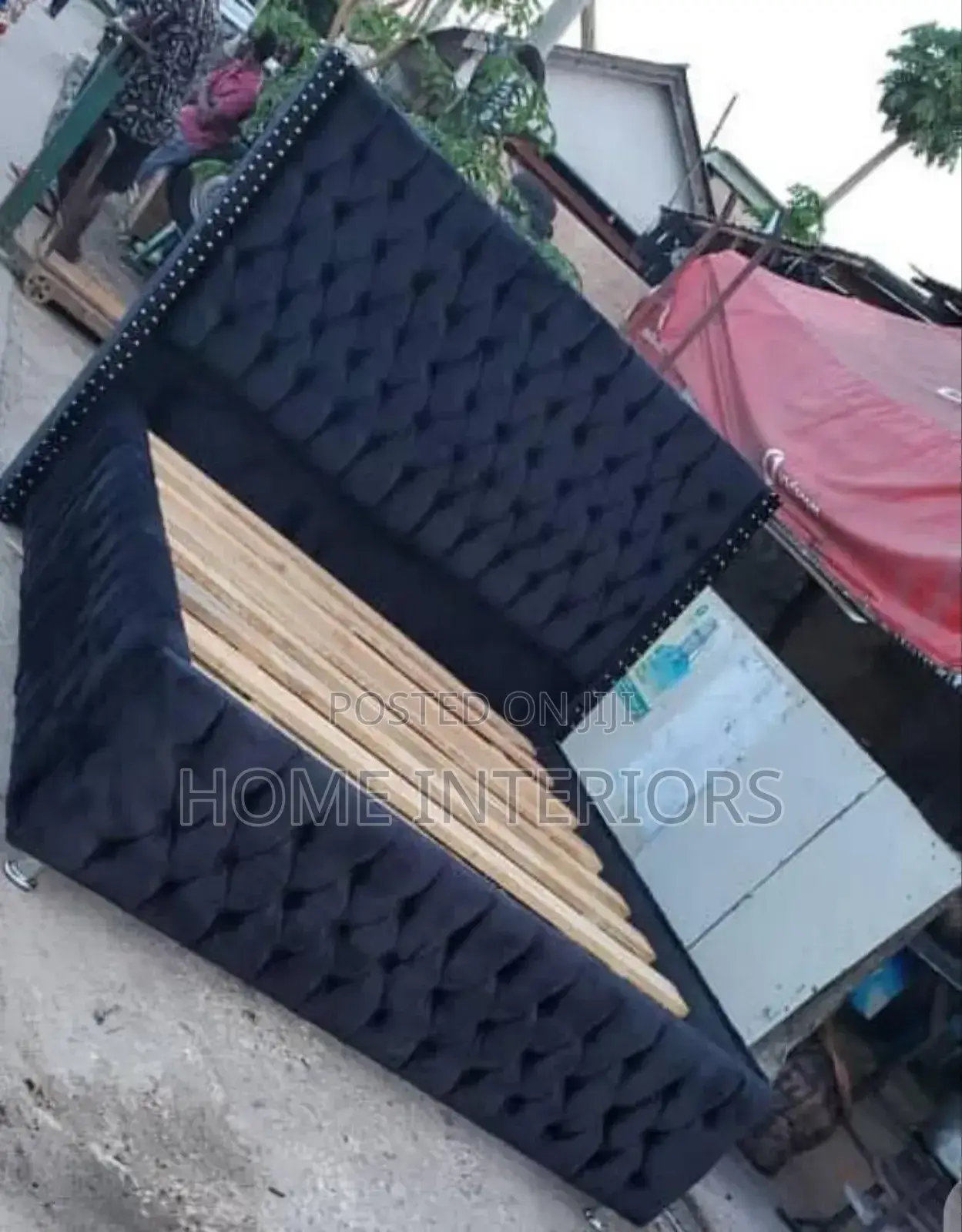 A Black Bed With Sliver Shinny Buttons