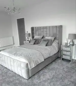 A Light Gray Colored Bed With a Mattress