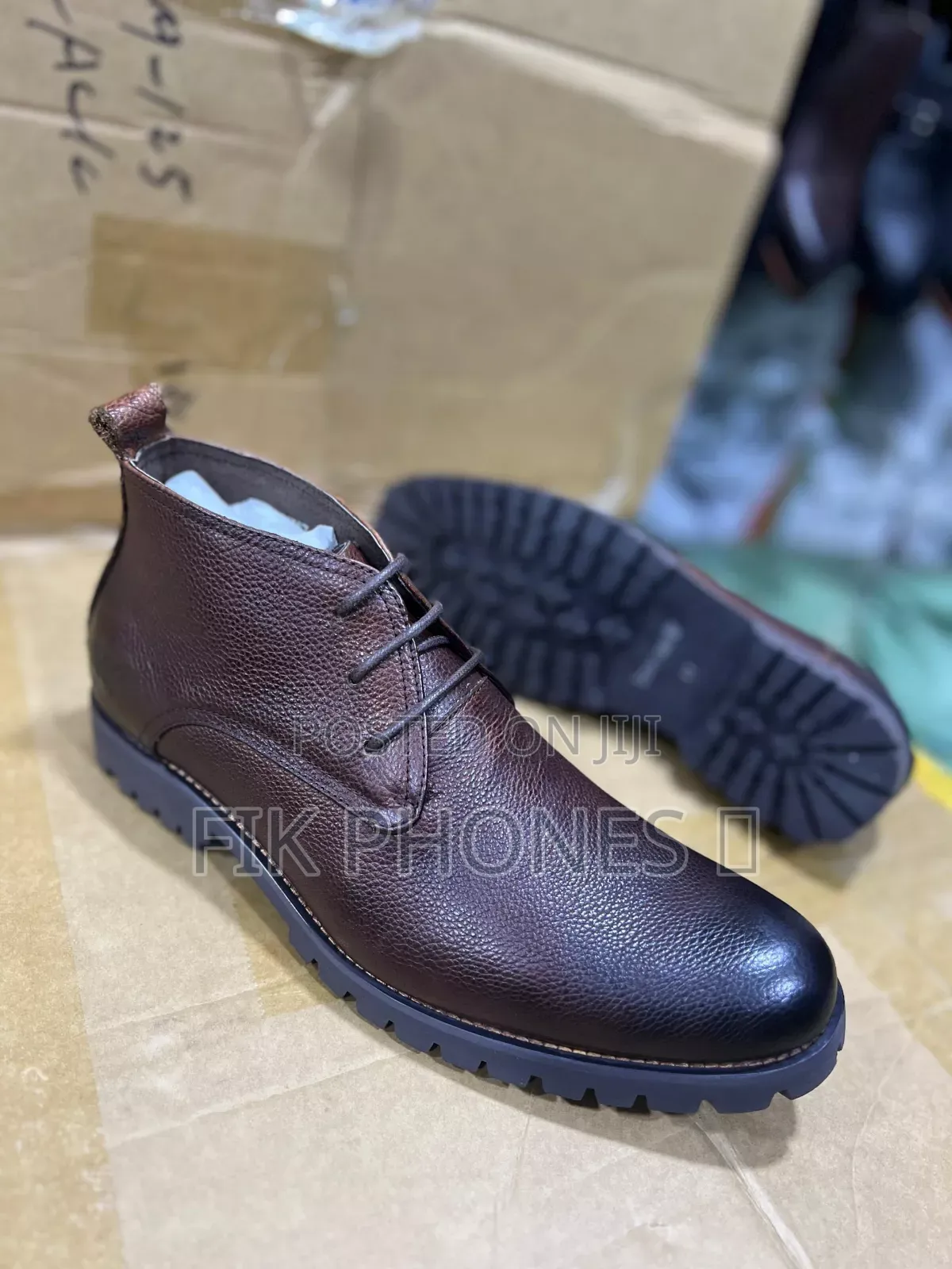 This Is a Pair of Brown Leather Lace-Up Boots With a Rugged Sole.