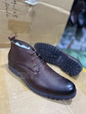 This Is a Pair of Brown Leather Lace-Up Boots With a Rugged Sole.