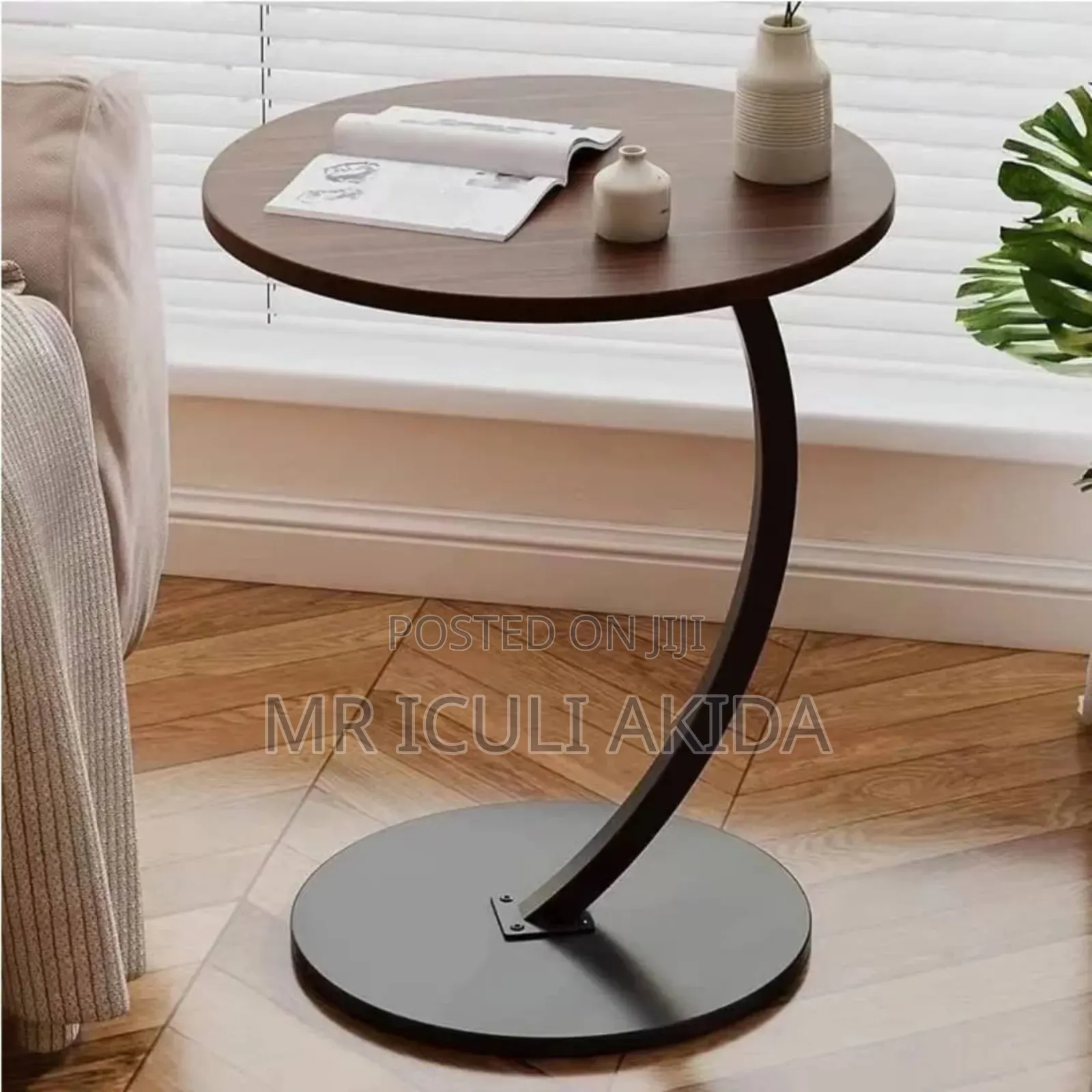 C-Shaped End Table With a Round Wooden Top and a Black Metal Base