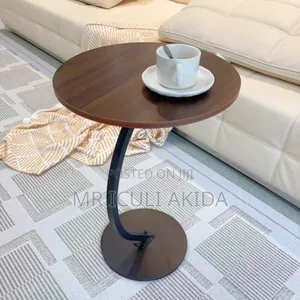 C-Shaped End Table With a Round Wooden Top and a Black Metal Base