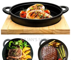 Cast Iron Sizzler Pan With A Wooden Serving Board