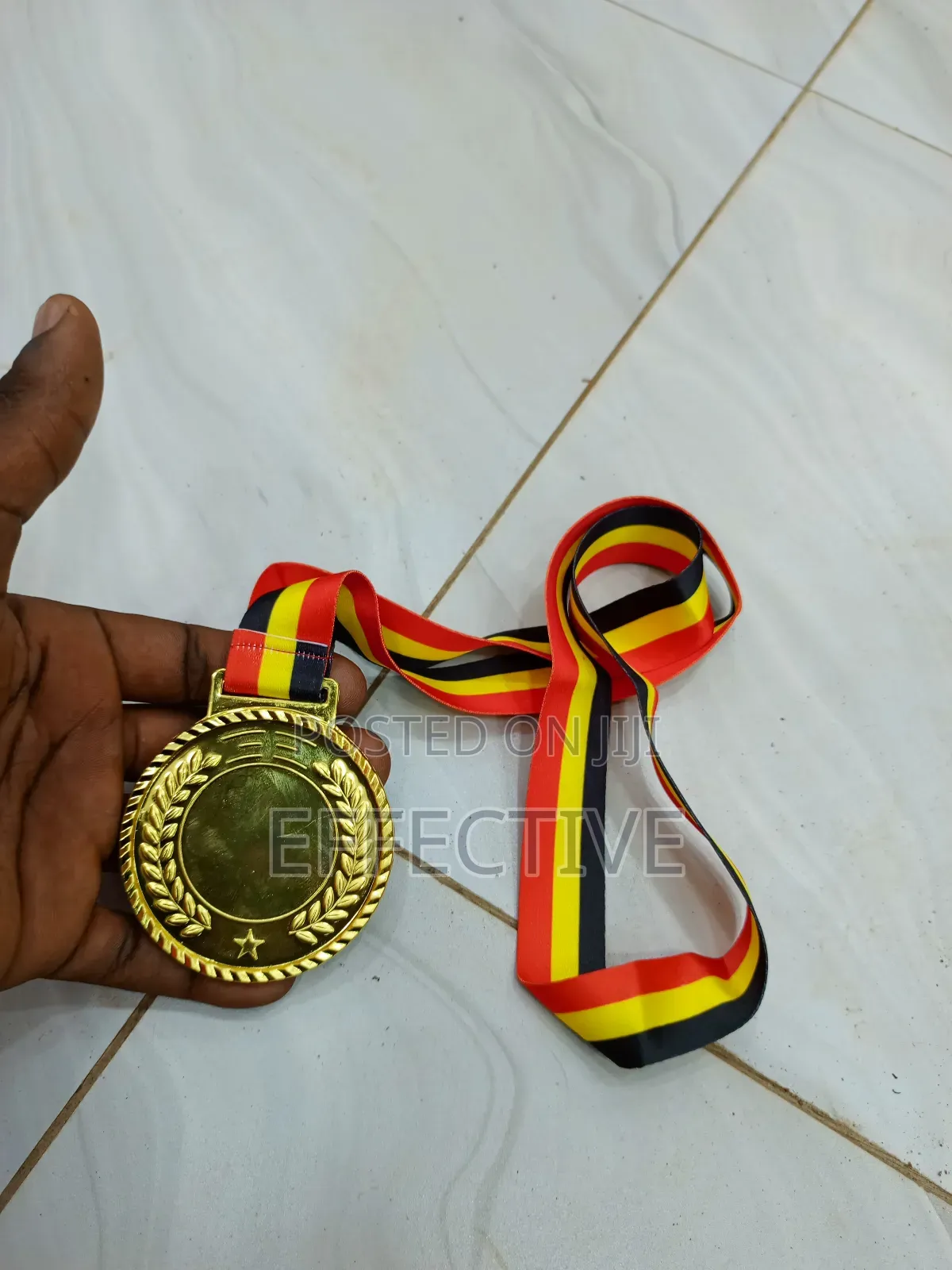 Gold Medal With a Red, Yellow, and Black Ribbon