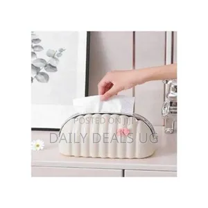 A Cream-Colored, Seashell-Shaped Plastic Tissue Box Cover