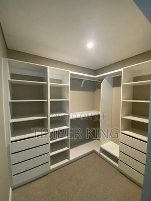 Custom-Built, White Walk-in Closet Designed for Efficient Storage in ...