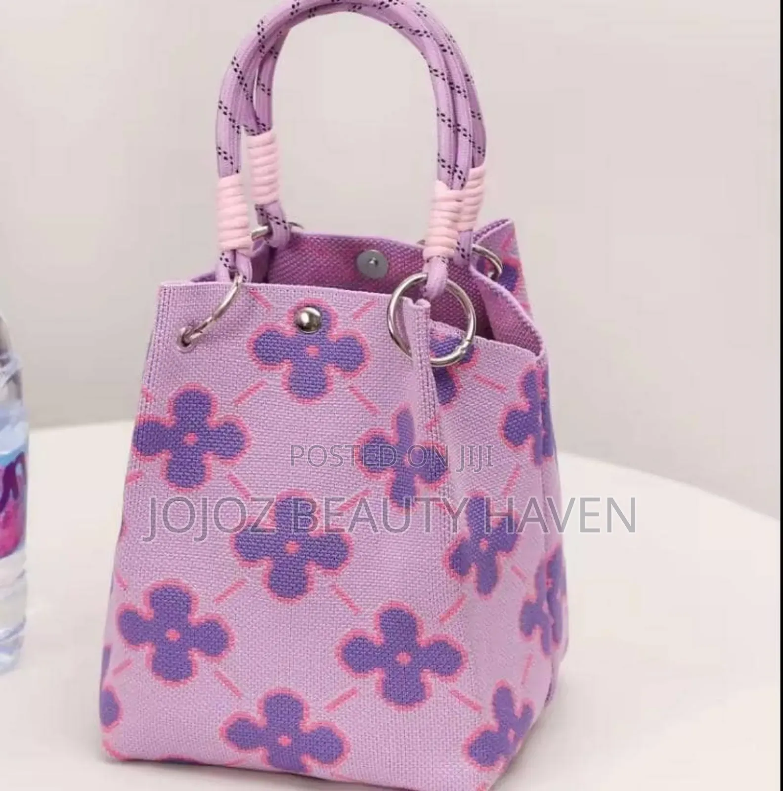 Knitted Bucket Bag With a Purple Flower Pattern.