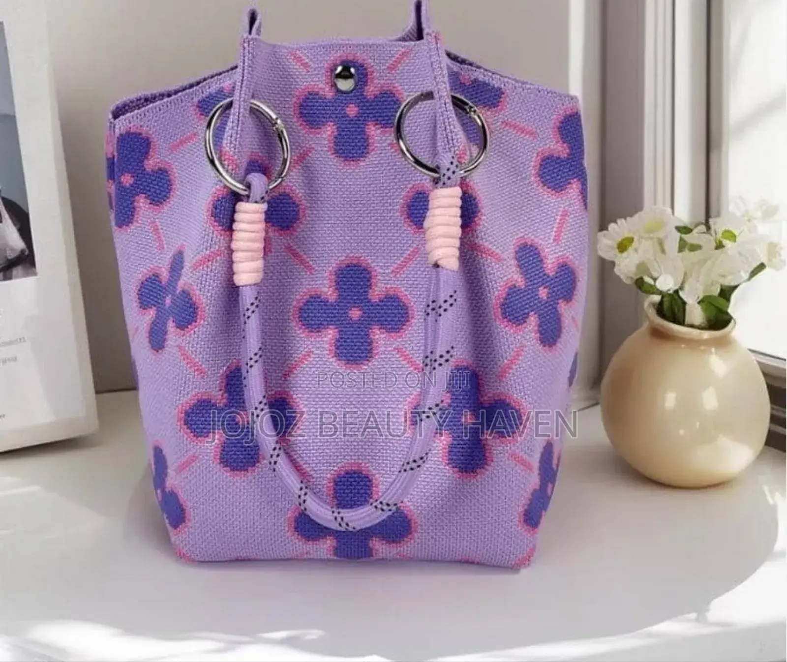 Knitted Bucket Bag With a Purple Flower Pattern.