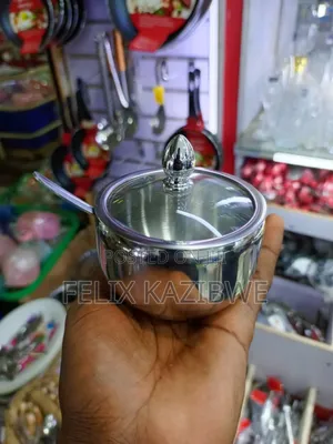 Stainless Steel Serving Pot With a Glass Lid and Spoon.