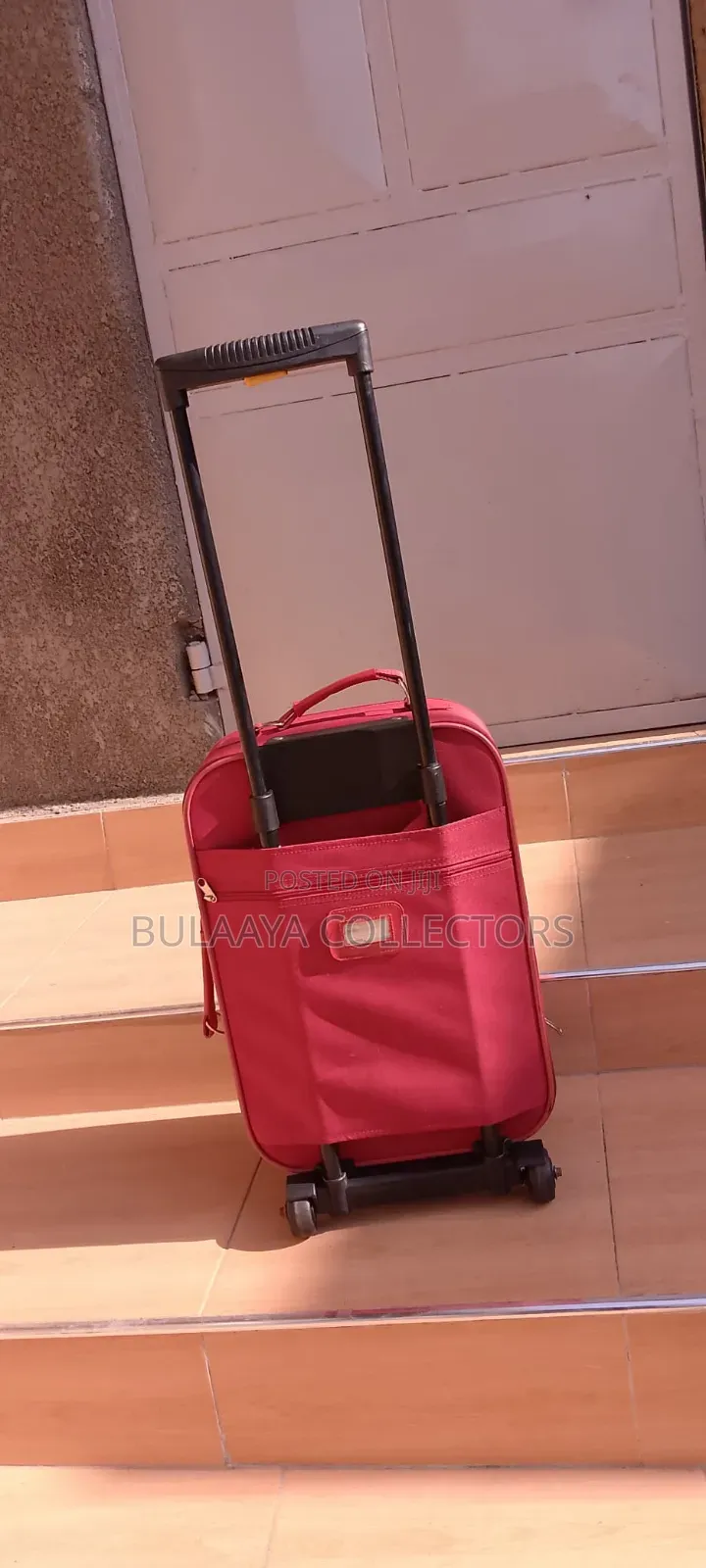 Japanese Red Soft-Sided Trolley Luggage Bag With an Extendable Handle.