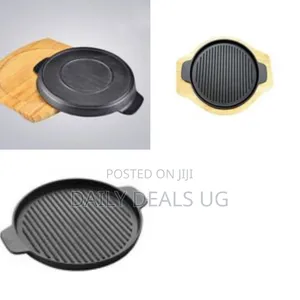 A Round Cast Iron Sizzling Plate With a Wooden Base