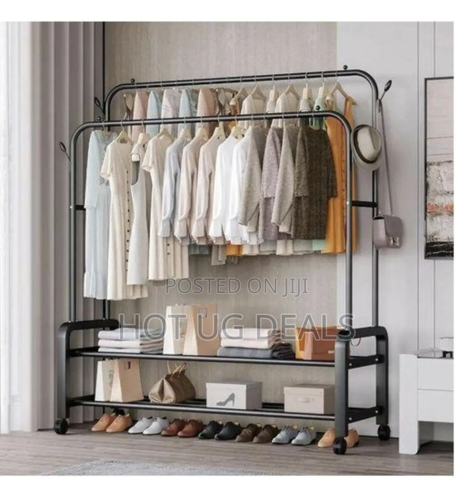 Metallic Garment Rack With Integrated Shelving And Caster Wheels.