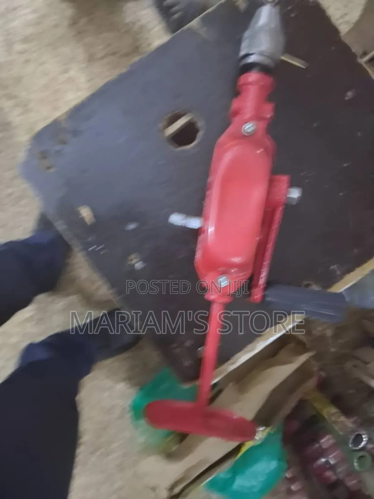 Red Hand-Crank Drill With a Chest Plate for Added Leverage.