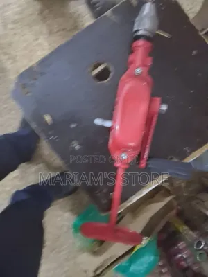 Red Hand-Crank Drill With a Chest Plate for Added Leverage.