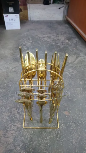 Gold-Plated Cutlery Set Features 24 Pieces in a Matching Wire Stand.