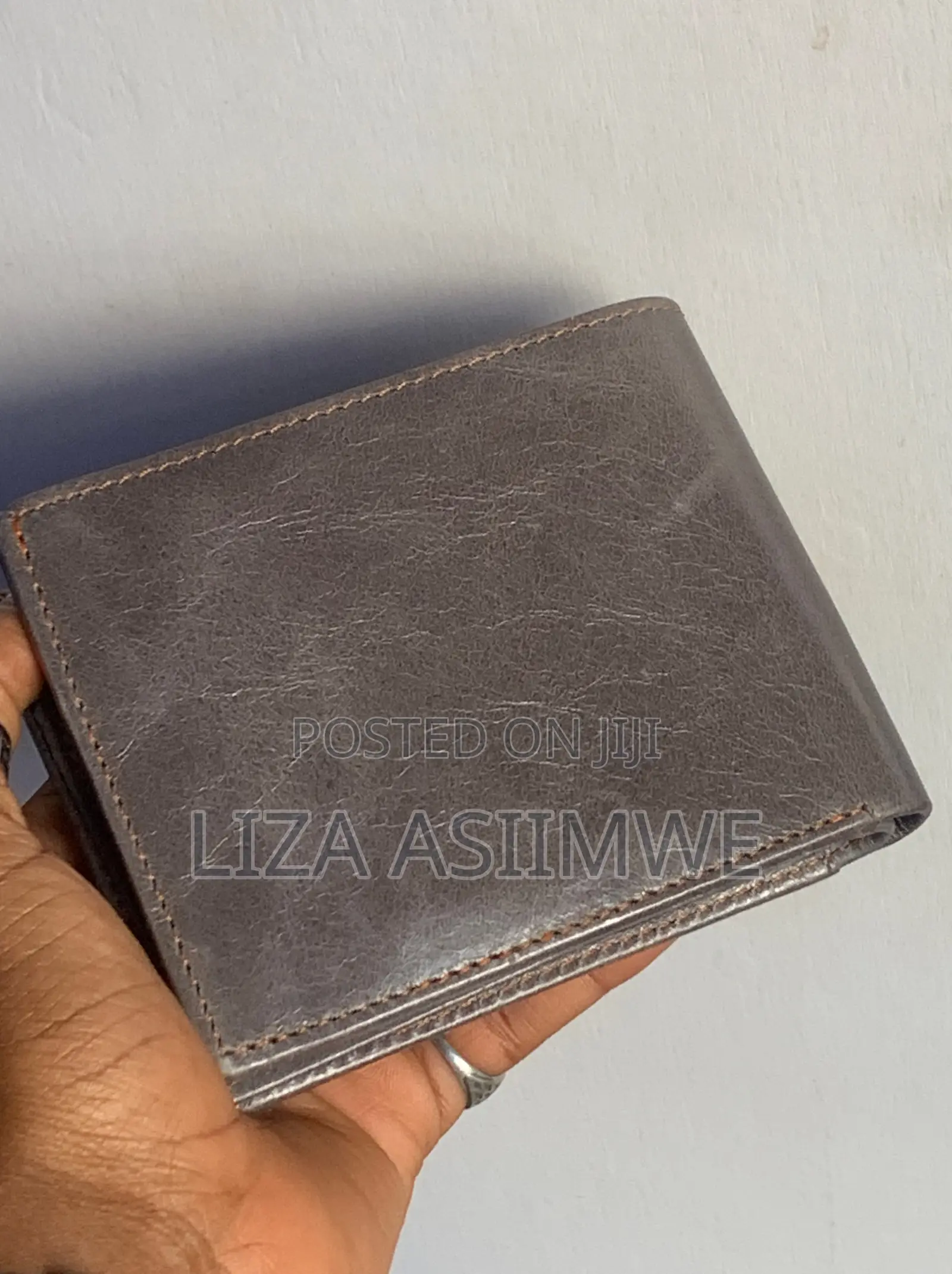 Leather Wallet Features A Textured Finish And An Embossed Logo
