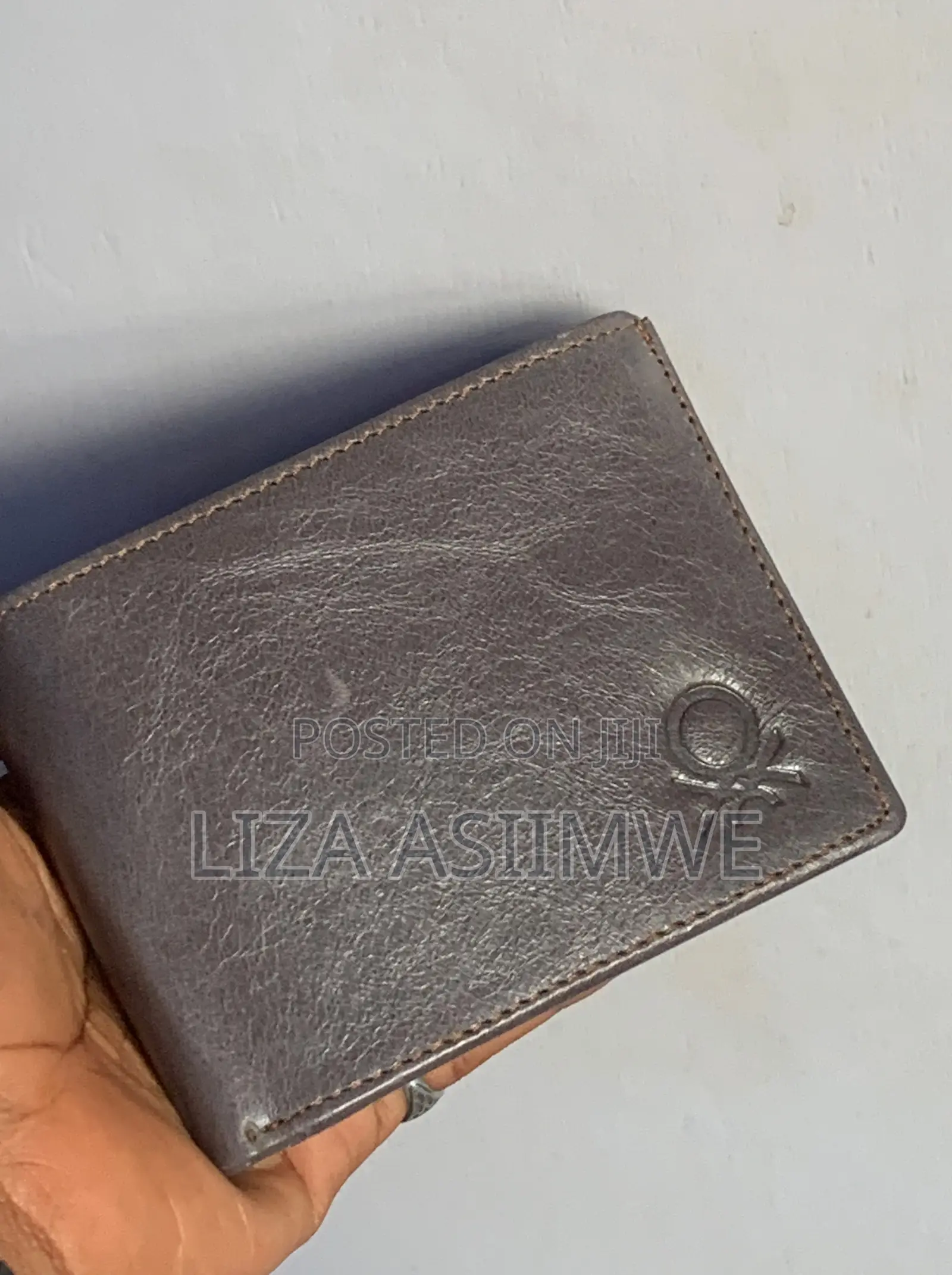 Leather Wallet Features A Textured Finish And An Embossed Logo
