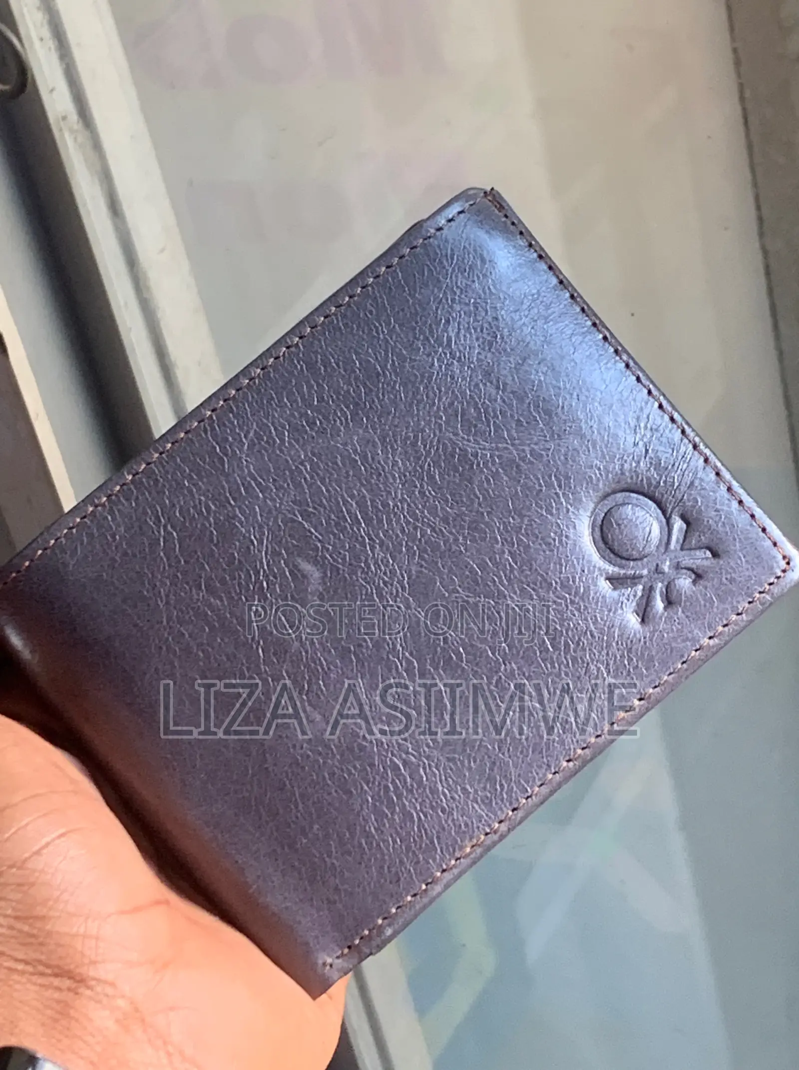 Leather Wallet Features A Textured Finish And An Embossed Logo