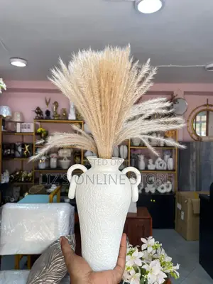 White Ceramic Vase From Awnr Features a Textured Surface.