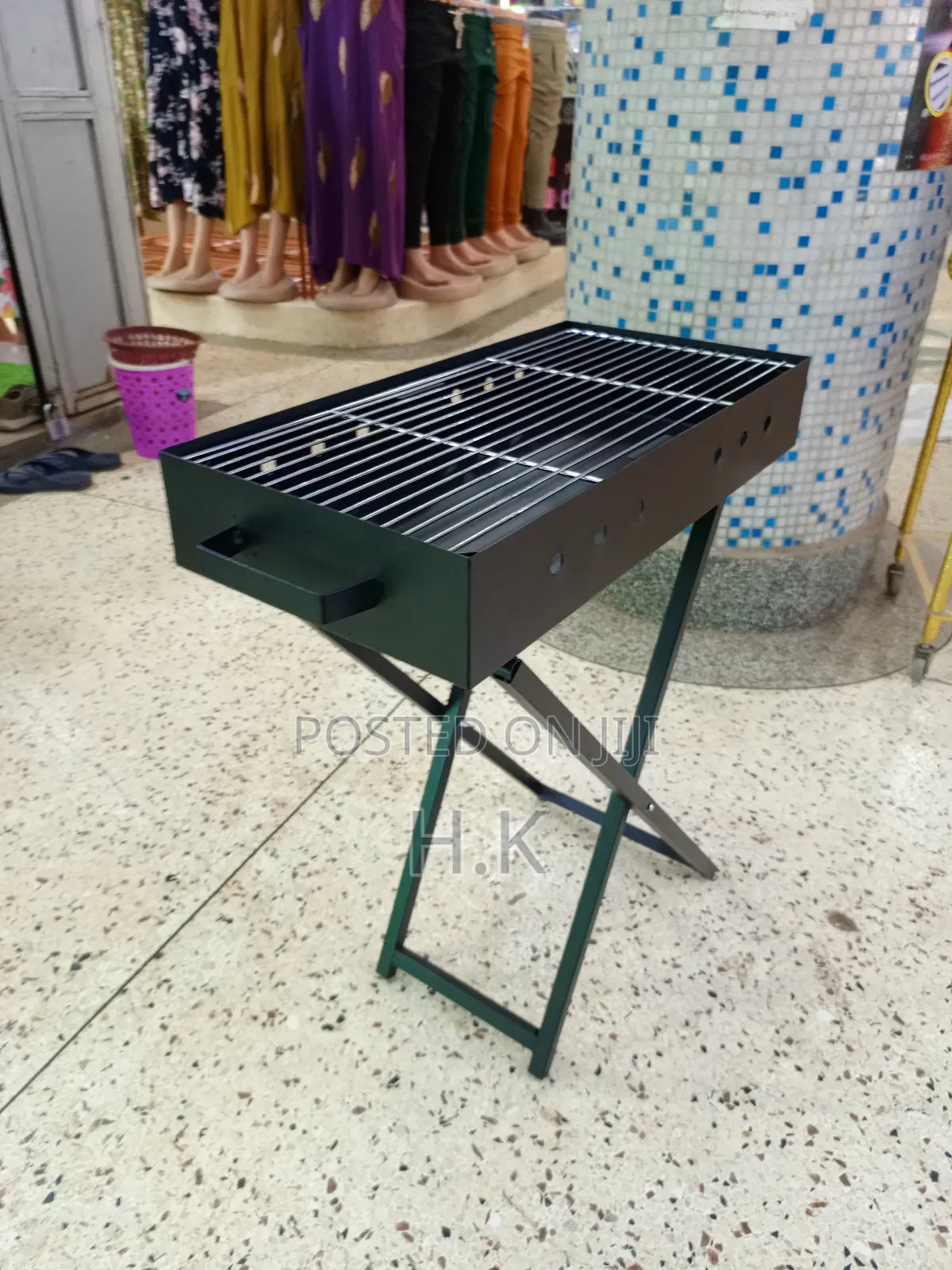 Portable Charcoal Barbecue Grill Featuring a Foldable X-Shaped Stand.