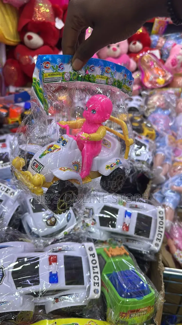 Pink Doll Is Seated Atop a White Toy Quad Bike