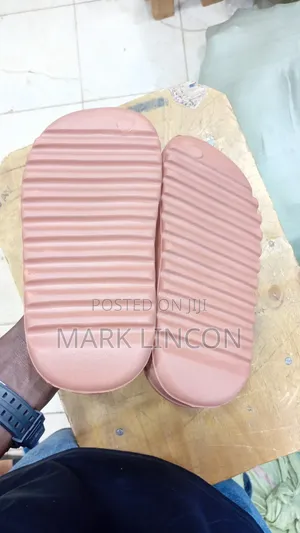 Adidas Yeezy Slides in a Dusty Rose or Ochre Colorway.