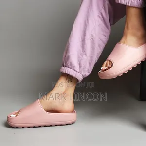 Adidas Yeezy Slides in a Dusty Rose or Ochre Colorway.