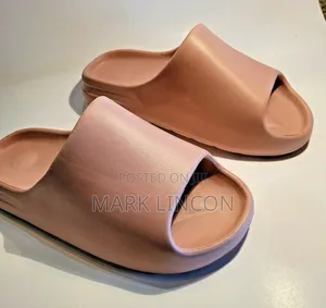 Adidas Yeezy Slides in a Dusty Rose or Ochre Colorway.