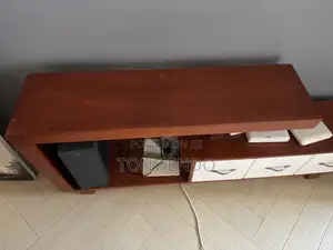 Tv Stand With a Modern Asymmetrical Design With White Drawer Fronts.