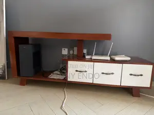Tv Stand With a Modern Asymmetrical Design With White Drawer Fronts.