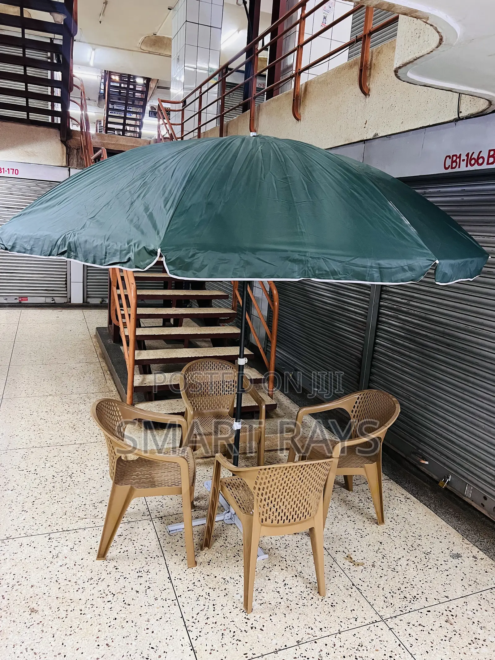 Round Patio Umbrella With a Stand and Four Chairs