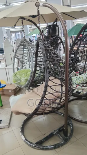 Egg Swing Chair Features a Sturdy Steel Stand and Beige Cushions.