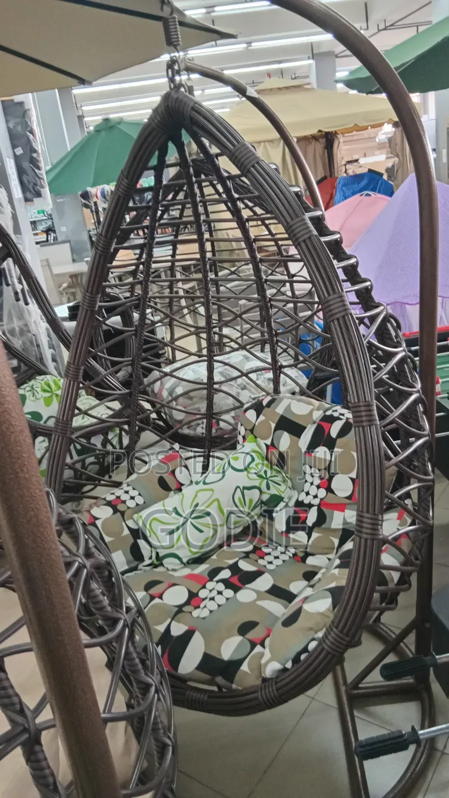 Egg Swing Chair Features a Sturdy Steel Stand and Beige Cushions.
