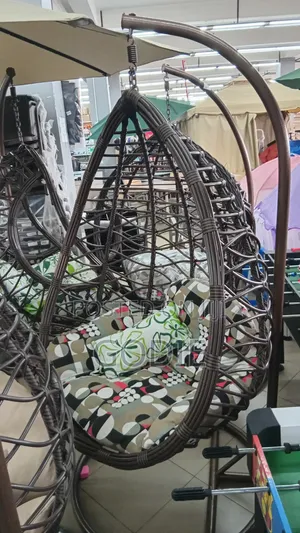 Egg Swing Chair Features a Sturdy Steel Stand and Beige Cushions.