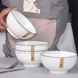 White Ceramic Bowls With Vertical Fluted Ridges and Dark Rims.
