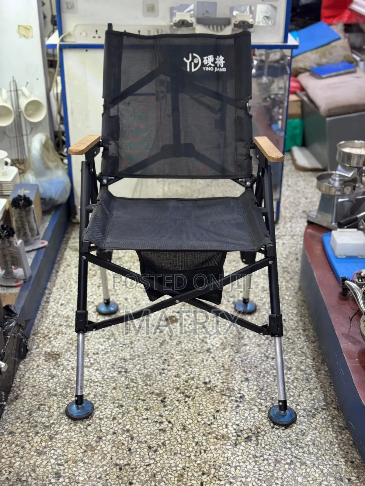 Portable Folding Camping Chair With a Fabric Seat and Wooden Armrests.