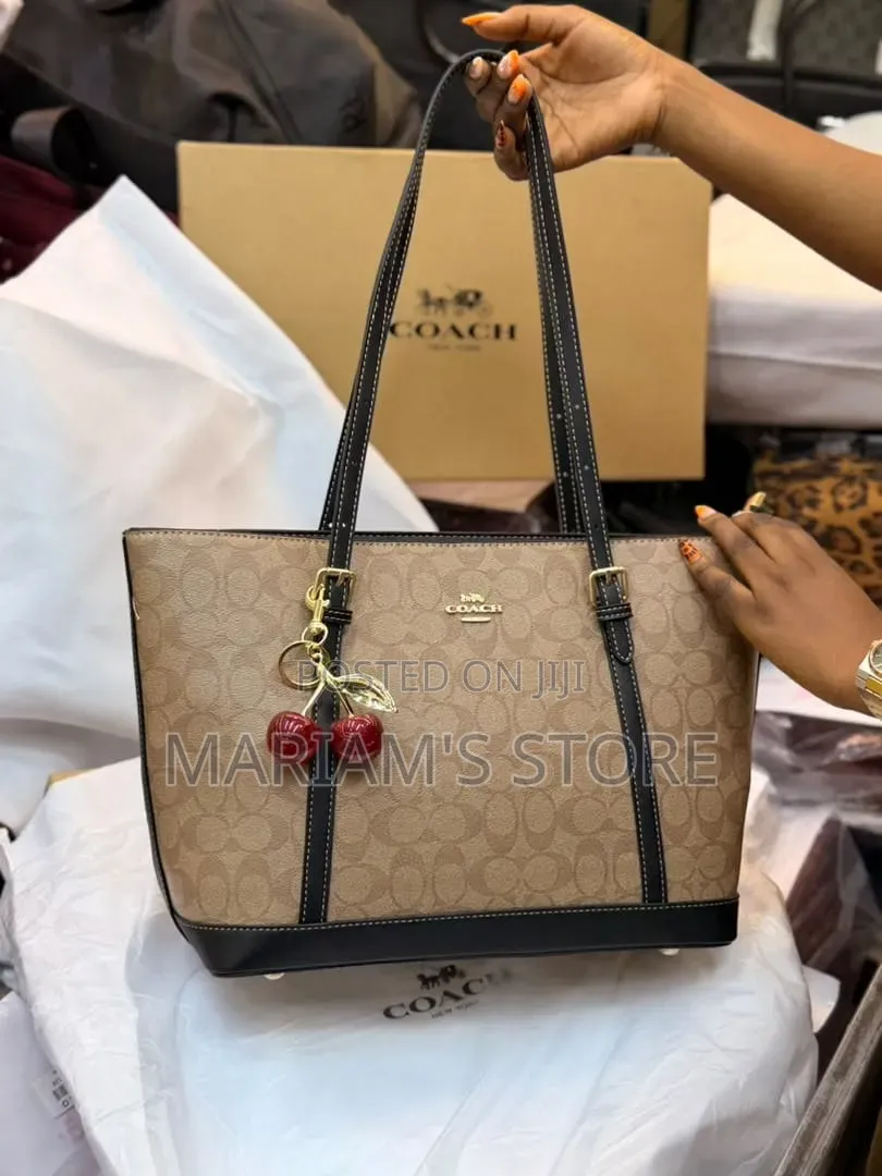 Coach Signature Canvas Tote Bag Accented With a Playful Cherm