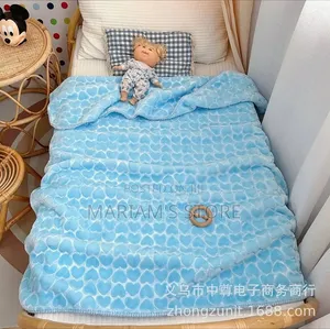 Soft Baby Blanket With an Embossed Heart on a Small Toddler Bed.