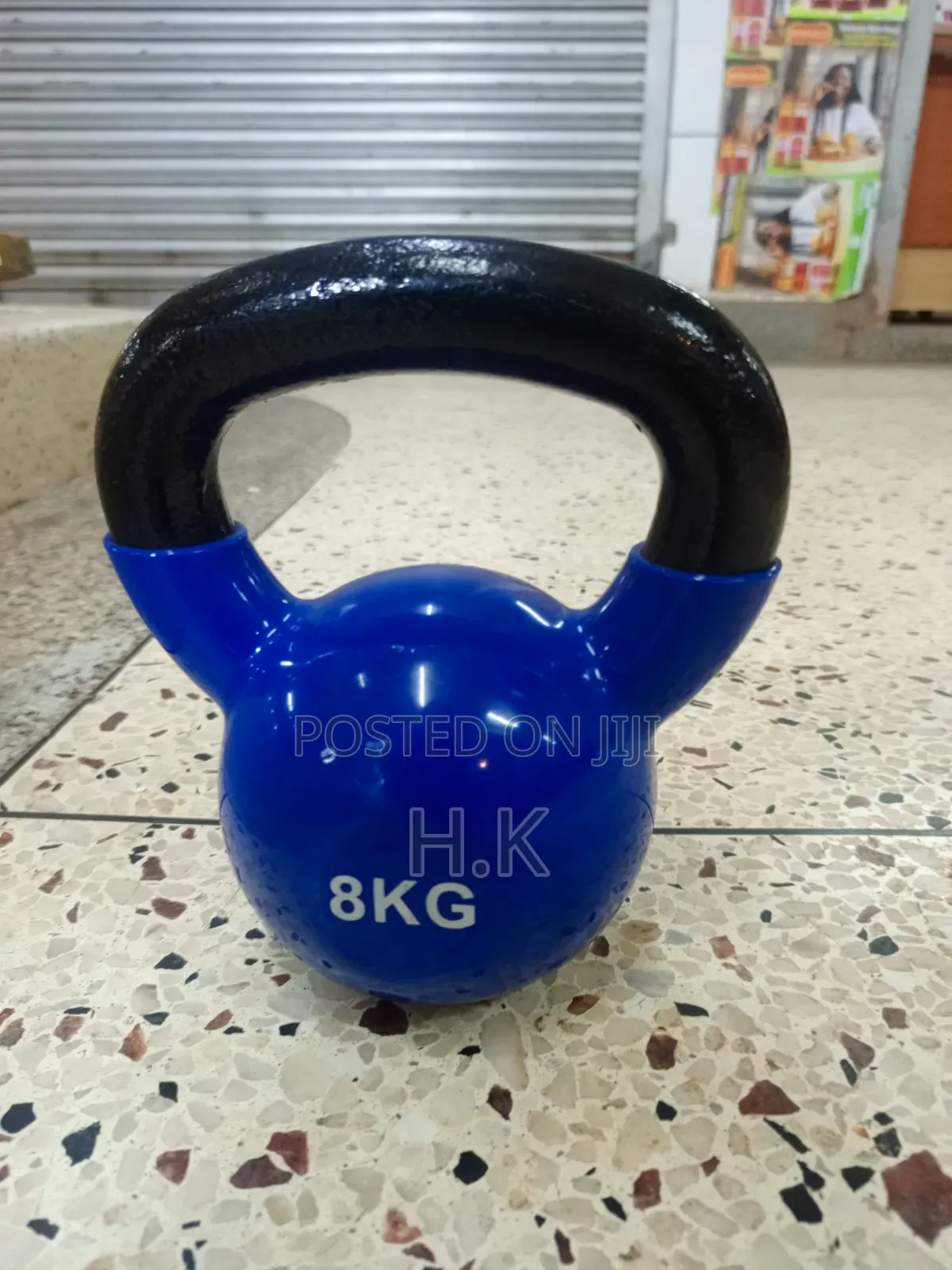 8kg Blue Vinyl-Coated Kettlebell With a Black Textured Handle.