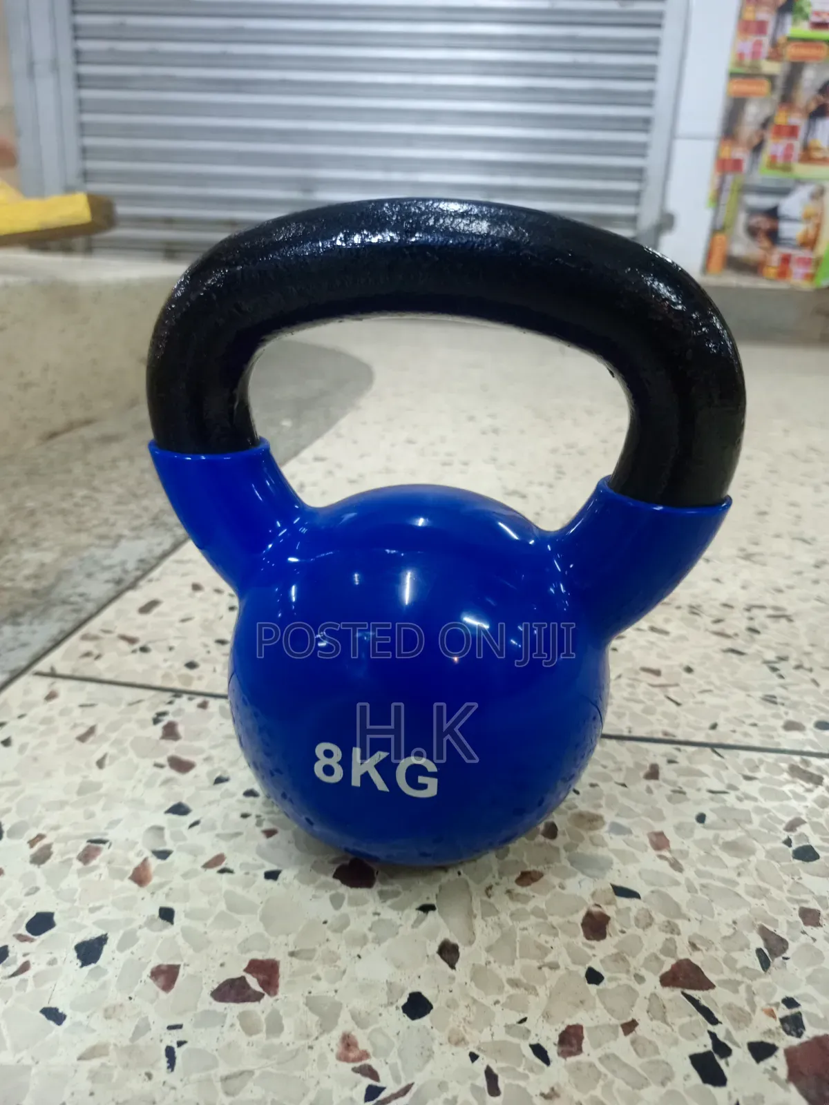 8kg Blue Vinyl-Coated Kettlebell With a Black Textured Handle.