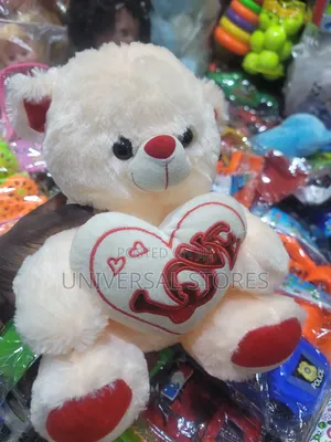 Cream-Colored Plush Teddy Bear Holding a White Heart Pillow