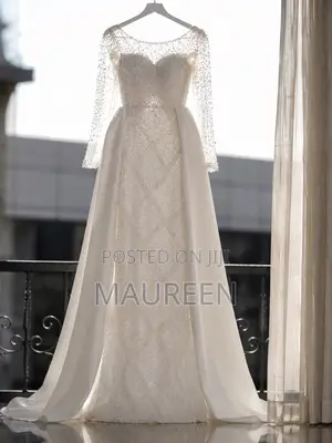 An Elegant White Beaded Bridal Gown With Veil and Satin Skirt