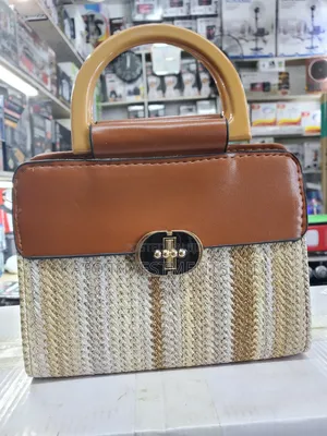 Top-Handle Handbag Featuring a Woven Straw Base in Earthy Tones