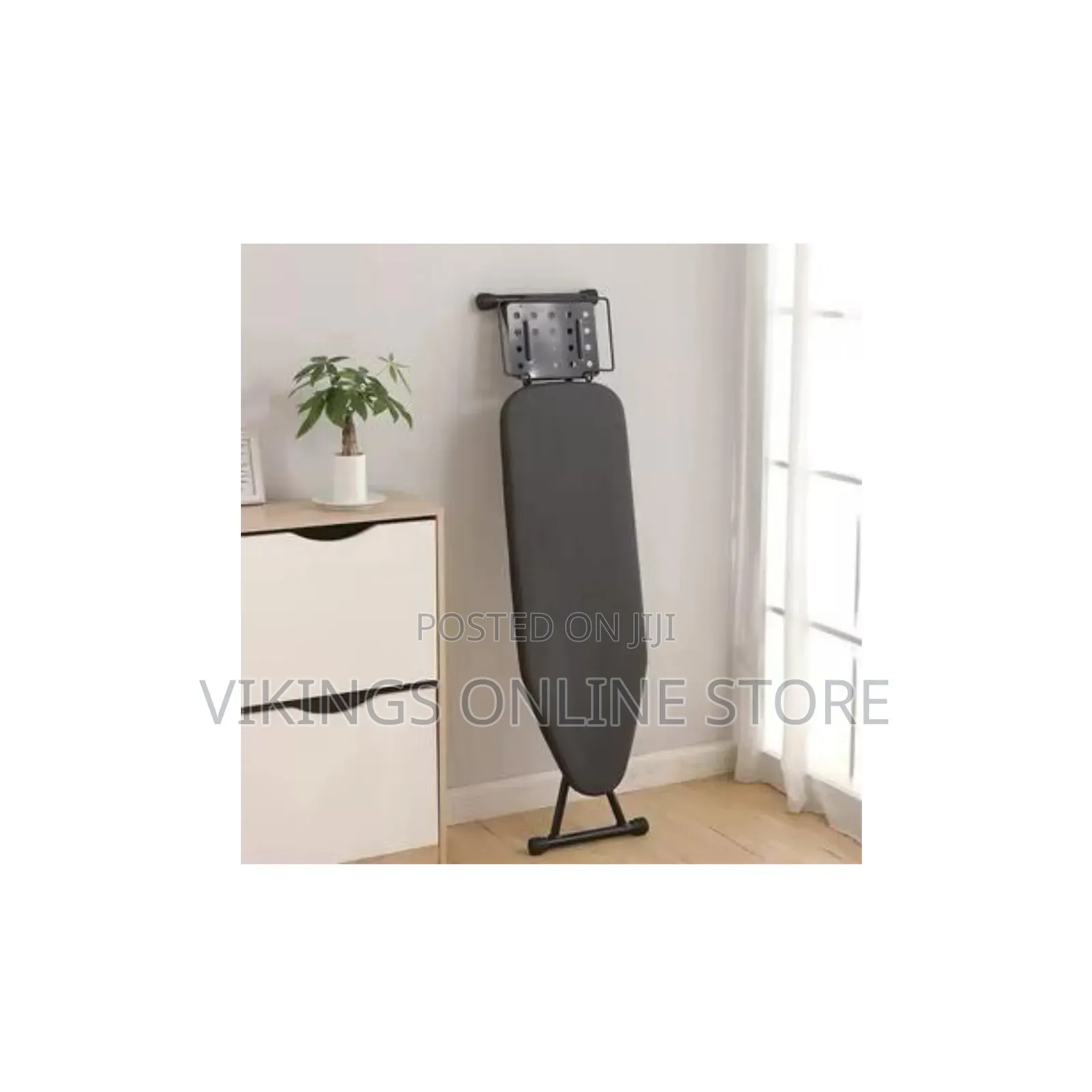 A Foldable Ironing Board With Iron Rest Plate